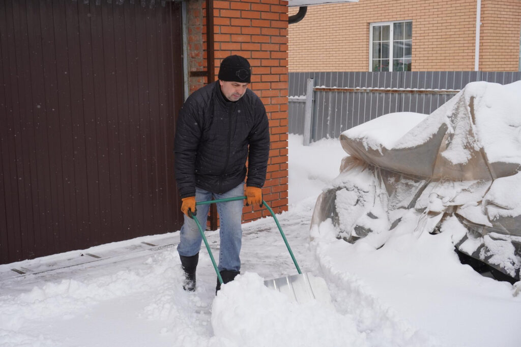 Mitarbeiter beim Winterdienst räumt Schnee vor einer Einfahrt in Neumarkt